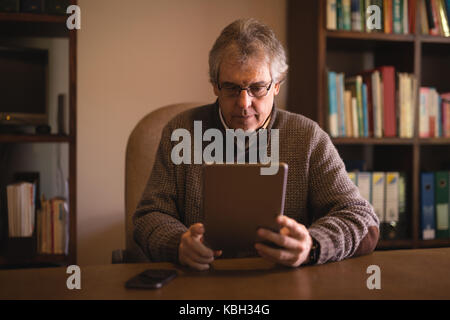 Man using digital tablet at desk at home Stock Photo