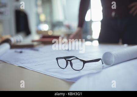 Close-up of spectacles on blueprint in studio Stock Photo