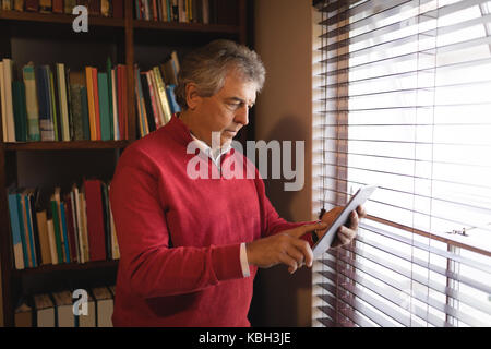 Man using digital tablet near window at home Stock Photo