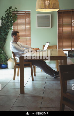 Man using laptop in living room at home Stock Photo