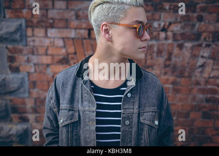 Stylish man posing against brick wall Stock Photo
