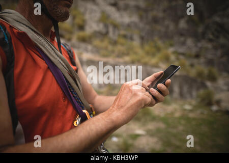 Mid-section of hiker using mobile phone Stock Photo