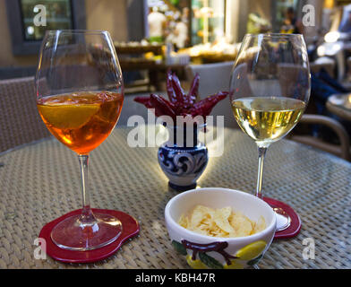 Amalfi, Italy, August 11 2014: Happy hour in Amalfi. Two glass, one with a spritz and the other with white wine, with the traditional Amalfi ceramics  Stock Photo