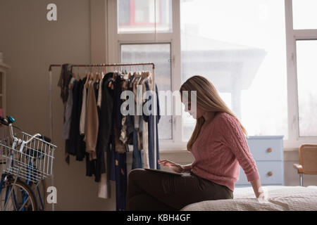 Relaxed young woman using tablet on bed at home Stock Photo