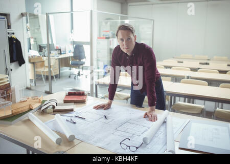Portrait of confident architect standing at table in studio Stock Photo