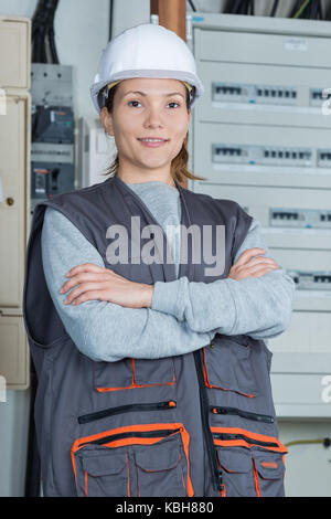 woman electrician posing next to the panel Stock Photo