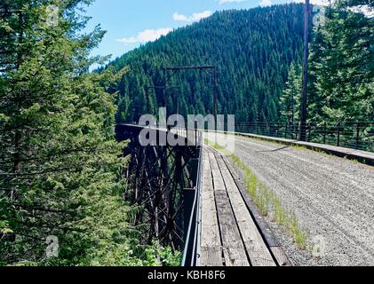 Long view of Cyclists on a Trestle bridge on the Hiawatha Trail Stock Photo