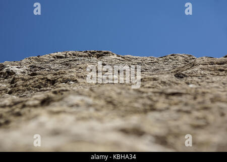Close up old and dirty rock or stone texture, blue sky background and selective focus Stock Photo