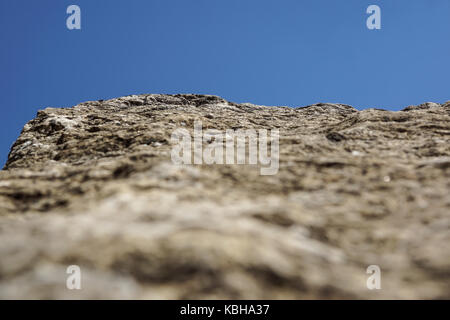 Close up old and dirty rock or stone texture, blue sky background and selective focus Stock Photo