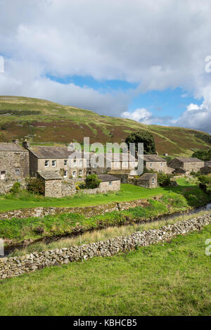 The village of Thwaite in Swaledale, Yorkshire Dales, England. Houses beside the stream. A location on the Pennine way. Stock Photo
