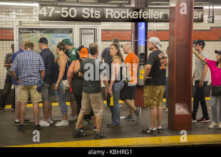 Riders study subway maps on the subway platform to figure out alternative routes due to train delays at the Rockefeller Center Station in midtown Manhattran, NYC. Stock Photo