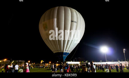 Colourful hot air ballon flying over night sky. Stock Photo