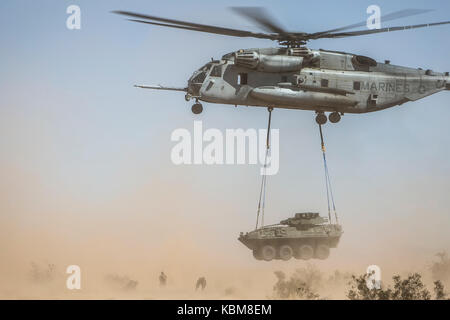 A CH-53E Super Stallion lifts a Light Armored Vehicle 25 during an external lift exercise during Weapons and Tactics Instructor Course (WTI) Stock Photo