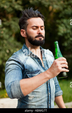 Hipster man with beard drinking a beer Stock Photo