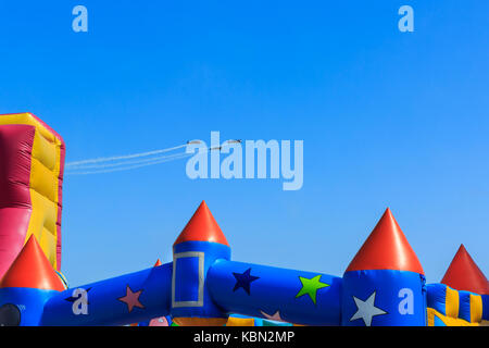 Extra EA-300 two seater aircraft of The Blades British civilian aerobatic team display at Airbourne, flying over a bouncy castle at Eastbourne Air sho Stock Photo