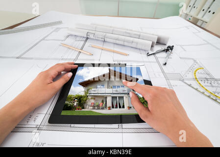 Businessperson Hands With Digital Tablet Over Blueprint In Office. Blueprints were created by photographer Stock Photo
