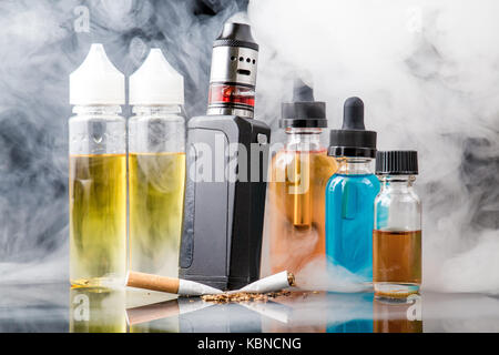 Modern vaporiser versus old tobacco cigarette in smoke cloud Stock Photo