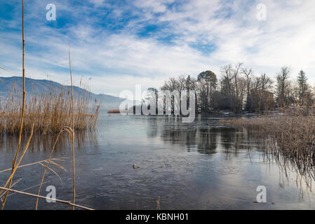 Frozen lake, northern Italy. Lake Varese in winter from Biandronno and the islet virginia, important site of prehistoric finds,UNESCO Site Stock Photo