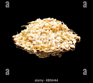 Bunch of dried flowers jasmine plants. Chinese tea additive for brewing. On a black glossy background with real reflection. Flower tea Stock Photo