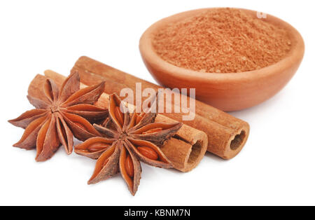 Some aromatic cinnamon with star anise and ground spice in a bowl over white background Stock Photo