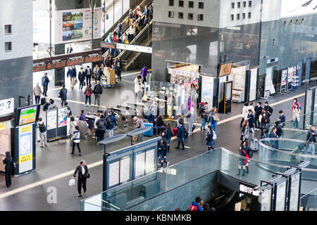 Kyoto station. Massive building designed by Hiroshi Hara. High viewpoint of ticket barrier and commuters going through to platforms. Stock Photo