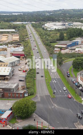 View of A48 dual carriageway from western end of pedestrian walkway of Newport Transporter Bridge, with light industrial units adjacent Stock Photo