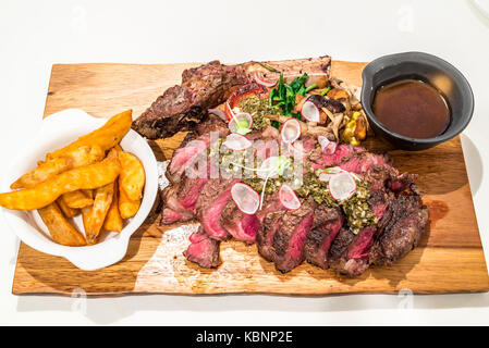 Grain fed Grilled Tomahawk Beef steak with fried potato wedge Stock Photo