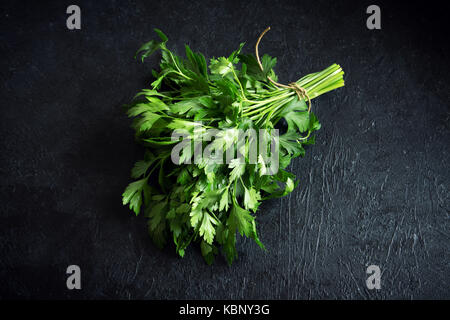 Organic Italian Parsley closeup on black background, healthy vegetarian food ingredient. Fresh Parsley. Stock Photo