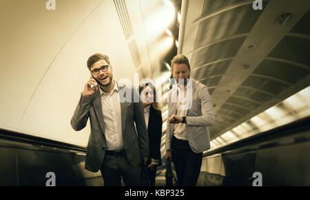 Coworkers using subway stairs together Stock Photo