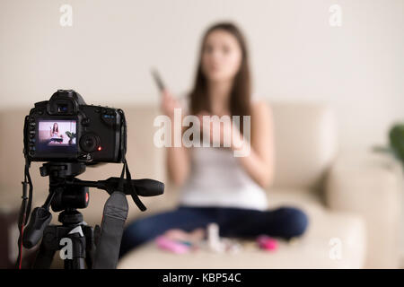 Young female videoblogger recording product review for blog. Stock Photo