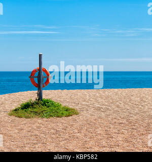 Deserted beach at Slapton Sands, Torcross, Devon UK with life ring on wooden post, blue sea and clear blue sky. Seafood Coast Stock Photo