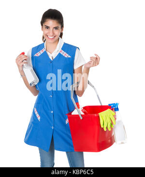 Portrait of happy female worker carrying bucket with cleaning equipment against white background Stock Photo