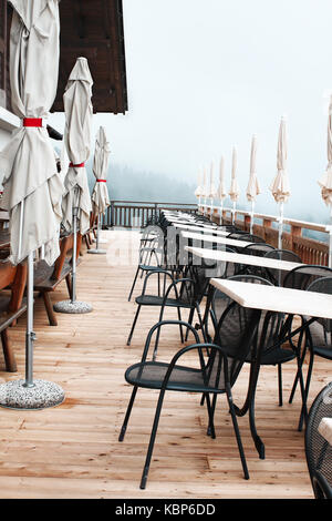 Convoluted restaurant umbrellas, chairs and tables in the outdoor mountain restaurant in the South Tyrolean Alps Stock Photo
