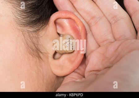 Closeup of young woman wearing hearing aid Stock Photo