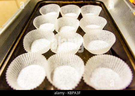 Empty paper muffin cups on baking tray Stock Photo