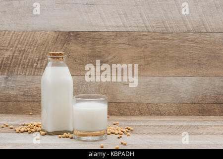 Bottle of soy milk and soybean on wooden table Stock Photo