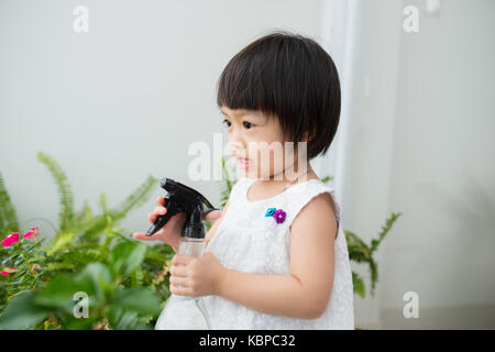 Child taking care of plants. Cute little girl watering first spring flowers Stock Photo