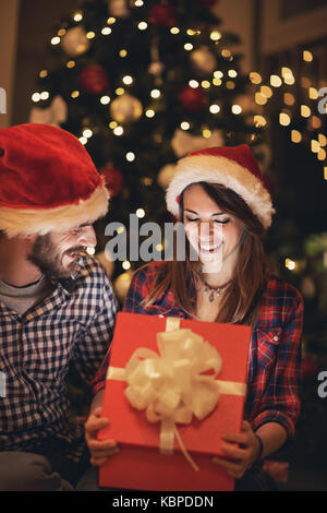 Girlfriend looks in opening box with New Years gift from boyfriend Stock Photo