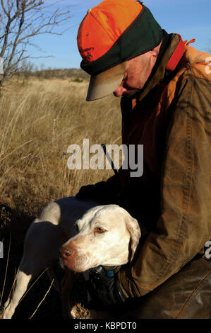 A quail hunter embracing his English Pointer hunting dog in West Texas Stock Photo