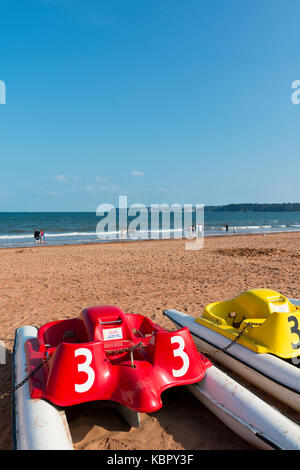 Sandy beach and pedaloes at Goodrington Sands, Paignton, Devon, UK with Berry Head and Brixham  in the distance on a clear blue sunny summer's day. Stock Photo