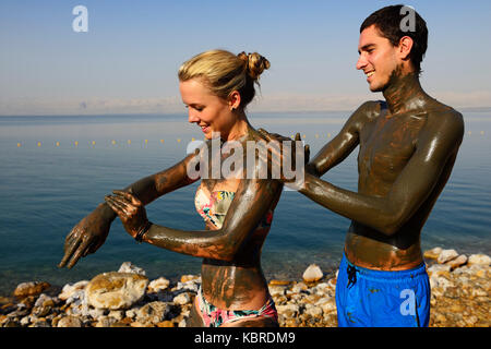 Young Couple uses Clay of Dead Sea for cleaning skin, Jordan Stock Photo