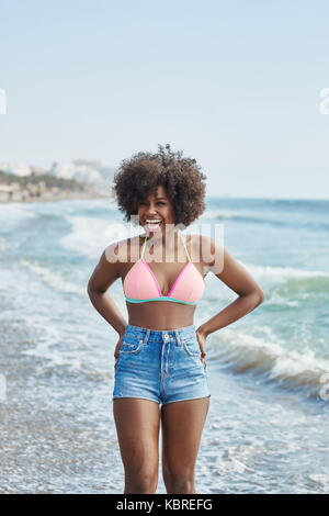 Portrait of pretty afro american girl standing in water laughing Stock Photo