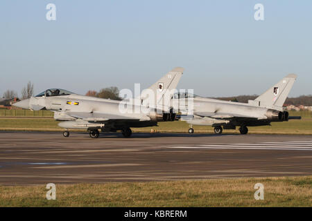 Two RAF Eurofighter Typhoon FGR4's lined up and about to depart RAF Coningsby's runway 25 in the winter sunshine. Stock Photo