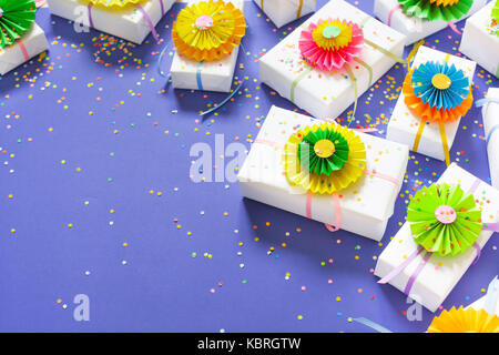 Lilac background. Many gifts of different sizes. White gift boxes. Stock Photo