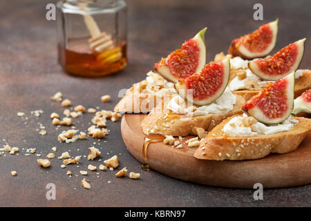 sandwiches with figs, ricotta, honey and walnuts on a brown background Stock Photo