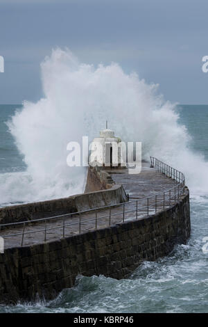 Breaking wave against a sea wall - Portreath, Cornwall Stock Photo