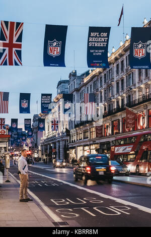 Black taxi and red bus on Regent Street, London. The street is decorated with NFL flags to celebrate the event and four NFL games played in capital Stock Photo