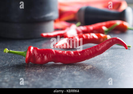 Red chili peppers on kitchen table. Stock Photo