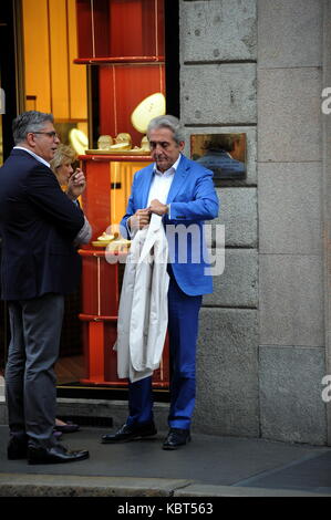 Milan, Pietro Lorenzetti walking with his wife in the center Professor Pietro Lorenzetti, renowned plastic surgeon who has several studies throughout Italy, often frequents Barbara D'Urso's living room on Sunday Live on channel 5 when ALBERICO LEMME, discussed the character who always argues for his method of slimming with his diets (several characters from the world of entertainment have entrusted to him, primarily Silvio Berlusconi and Briatore). He is surprised to walk through the streets of the quadrilateral while curious among the showrooms of the boutiques, along with his wife and a frie Stock Photo