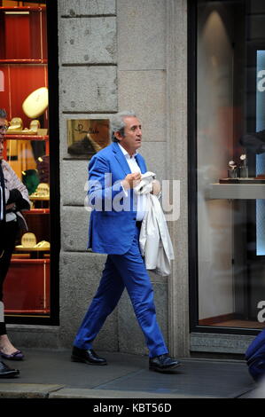 Milan, Pietro Lorenzetti walking with his wife in the center Professor Pietro Lorenzetti, renowned plastic surgeon who has several studies throughout Italy, often frequents Barbara D'Urso's living room on Sunday Live on channel 5 when ALBERICO LEMME, discussed the character who always argues for his method of slimming with his diets (several characters from the world of entertainment have entrusted to him, primarily Silvio Berlusconi and Briatore). He is surprised to walk through the streets of the quadrilateral while curious among the showrooms of the boutiques, along with his wife and a frie Stock Photo